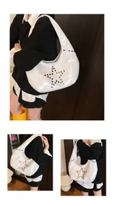 Detalle de bolso hobo de charol blanco con diseño de estrella de remaches metálicos