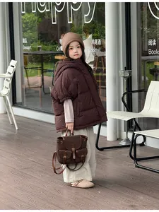 Buitenopname van een kind met een vintage donkerbruine suède rugzak en herfstoutfit