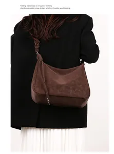 Detailed side view of brown suede shoulder bag featuring an elegant knot on the strap