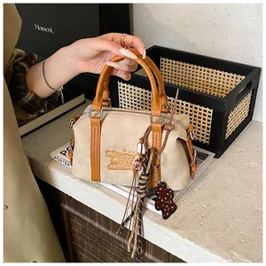 Detail of beige Boston bag featuring logo embroidery and leopard print bear pendant