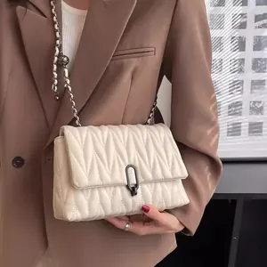 Quilted cream chain crossbody bag for women with V-shaped geometric texture and metal lock
