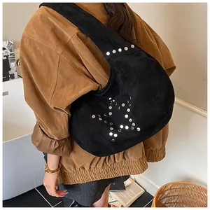 Detail of black suede hobo bag featuring silver rivet star design and textured finish