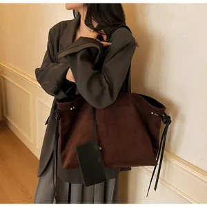 Détail du sac cabas en daim marron foncé avec gaufrage TOTEBAG et une petite pochette