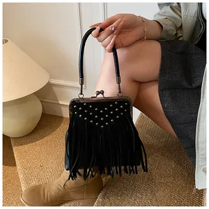 Close-up of retro black suede handbag featuring silver rivets and long tassel details