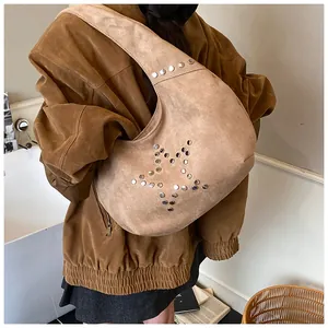 Close-up of khaki suede hobo bag featuring star rivet patterns on model shoulder