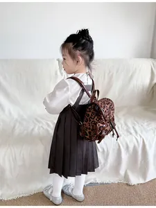 Detailweergave van kind met mini-rugzak met luipaardprint en kunstlederen afwerkingen