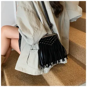 Close-up of black fringe shoulder bag with silver studs and vintage metal clasp closure