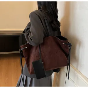 Vue détaillée du sac cabas en suédine marron avec lettrage embossé et pochette noire