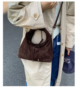 Details der dunkelbraunen Tasche aus Wildlederimitat mit Kordelzug und Schulterriemen