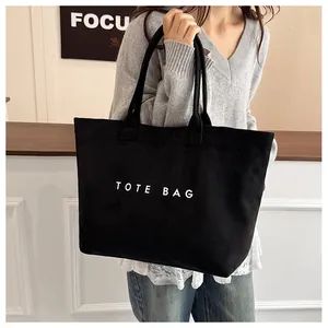 Détail du sac cabas noir en suédine avec lettrage TOTE BAG blanc et double bandoulière