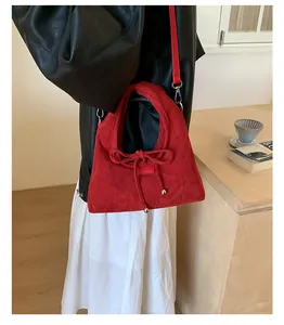 Nahaufnahme der roten Wildleder-Tote Bag mit kleiner Schleife und silbernen Metallperlen