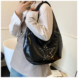 Detalle del bolso hobo negro con remaches de estrella en metal plateado