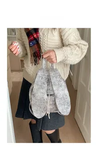 Detail of plush grey backpack featuring rabbit ears and white star patterns on a model