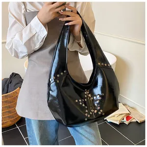 Detalle del bolso de hombro en cuero PU negro brillante con remaches de estrella plateada