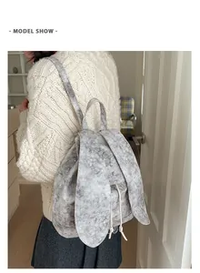Detail view of a grey tote backpack with cute bunny ears and silver star patterns