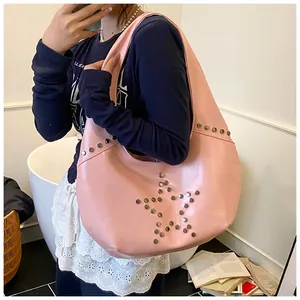 Bolso hobo rosa punk con remaches de estrella plateados llevado por modelo casuales