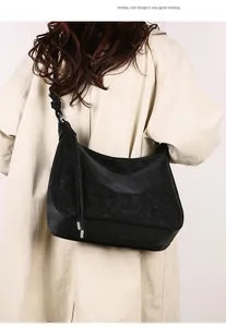 Detail of the textured black suede and leather hobo bag with side drawstring accents