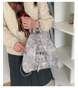 Detail view of a grey backpack with rabbit ears and star pattern in a winter outfit