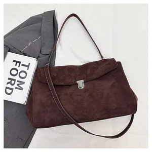 Detail of dark brown suede shoulder bag with silver clasp and dual straps