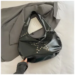 Detalle de bolso punk negro brillante con remaches plateados en forma de estrella y lujo