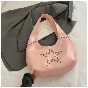 Vista detallada del bolso tote rosa con tachuelas de estrella plateadas y textura de cuero PU