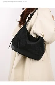 Detail of black suede tote bag featuring unique knotted strap and silver metal ring hardware