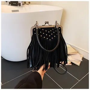 Detail of vintage black fringe handbag with rivets and retro clasp closure