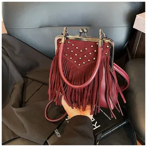 Detail of vintage burgundy tassel handbag with metallic studs and retro clasp closure