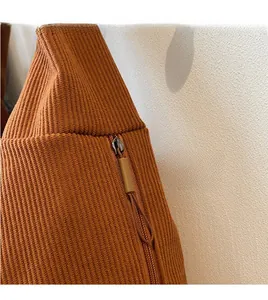 Detail of hidden zipper and long drawstring pull on caramel ribbed knit tote bag