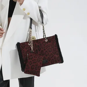 Large leopard print tote bag with chain strap and mini pouch shown on a model
