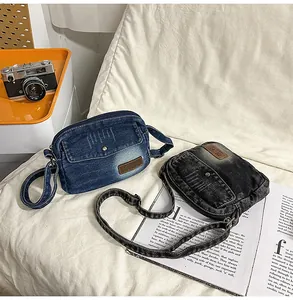 Détail de sacs bandoulière en jean délavé bleu et gris avec bandoulières réglables