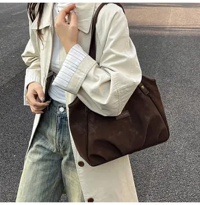 Dettaglio ravvicinato della borsa tote in pelle scamosciata marrone con finiture in metallo