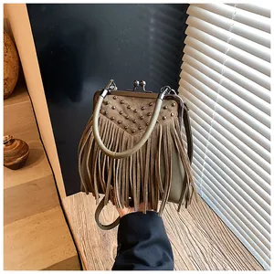 Macro shot of olive green tassel bag with vintage metal rivets and frame closure