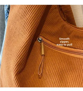 Close-up of caramel corduroy tote bag featuring a smooth metal zipper with fabric puller