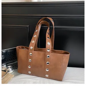 Detailed view of silver rivets on a premium brown faux leather tote bag for women