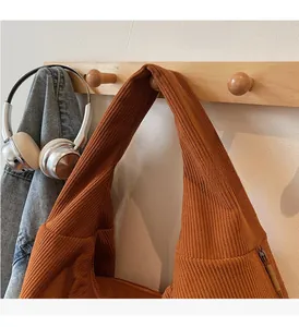 Detail of caramel orange corduroy tote bag with wide handle and vertical texture