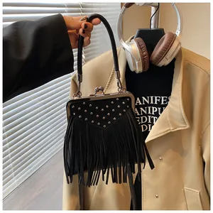 Close-up of black fringe bag with silver studs and vintage metal clasp closure