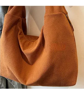 Close-up of caramel brown corduroy tote bag showing soft ribbed texture and wide strap