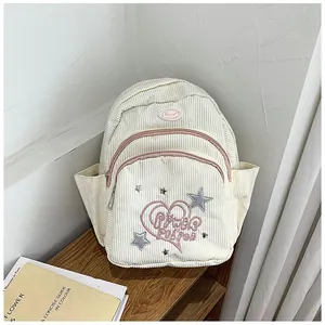 Détail du sac à dos en velours côtelé blanc cassé avec broderie cœur rose et étoiles