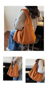 Macro shot of orange corduroy tote bag showing soft ribbed texture and wide strap detail