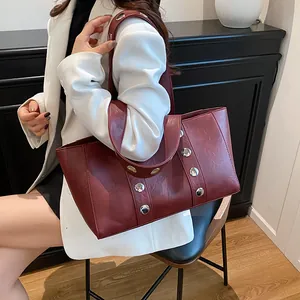Minimalist wine red leather tote bag with stylish silver rivets for daily commuting