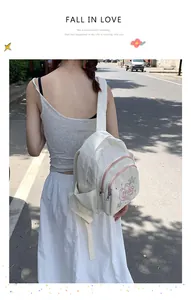 Détail d'un mini sac à dos en velours côtelé blanc cassé avec broderie de cœur