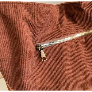 Close-up of caramel corduroy tote bag featuring a bronze metal zipper pocket detail