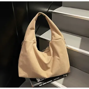 Minimalist khaki corduroy tote bag with wide shoulder strap on a modern staircase