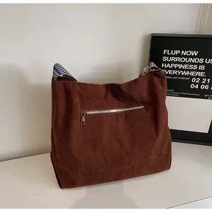 Detail of dark brown corduroy tote bag featuring colorful ethnic style shoulder strap