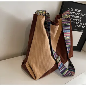 Detail of corduroy patchwork shoulder bag with colorful bohemian embroidered strap