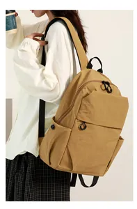 Close-up of lightweight yellow mini backpack with waterproof fabric on a model