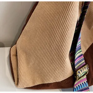 Detail of corduroy texture and ethnic style woven strap on large shoulder bag