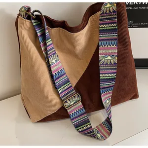 Detail of corduroy tote with khaki and brown stitching and a wide ethnic strap