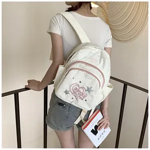 Gros plan du mini sac à dos en velours côtelé avec broderie cœur et étoile rose
